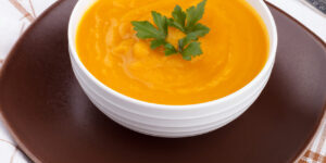 Pumpkin soup in a bowl on white wooden table