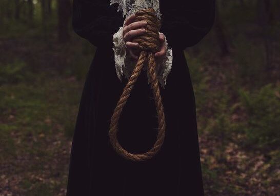 A person in black robe holding a rope