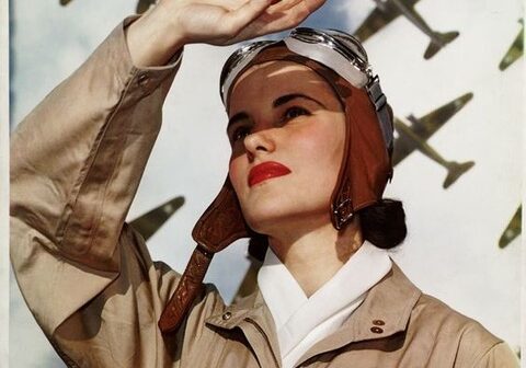 A woman saluting in front of planes.